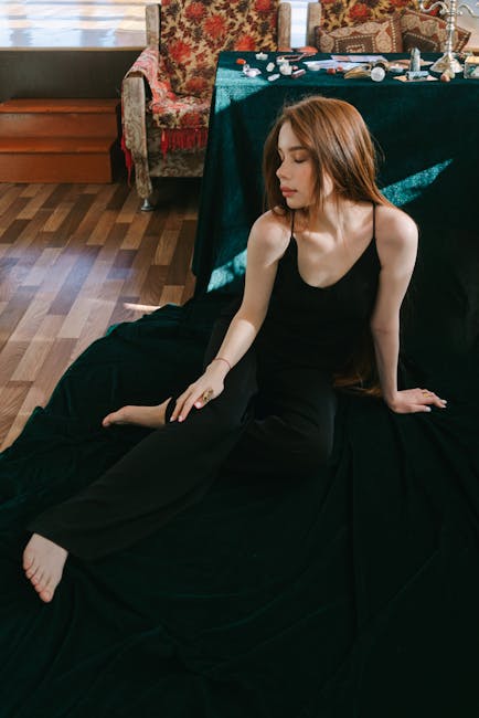 Person sitting comfortably on the floor next to a laptop with eyes closed, finding a moment of peace.
