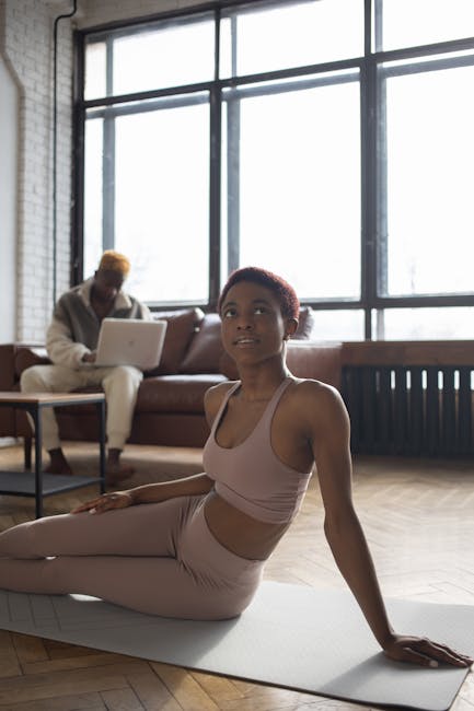 Woman stretching gently near a window in a bright living room.